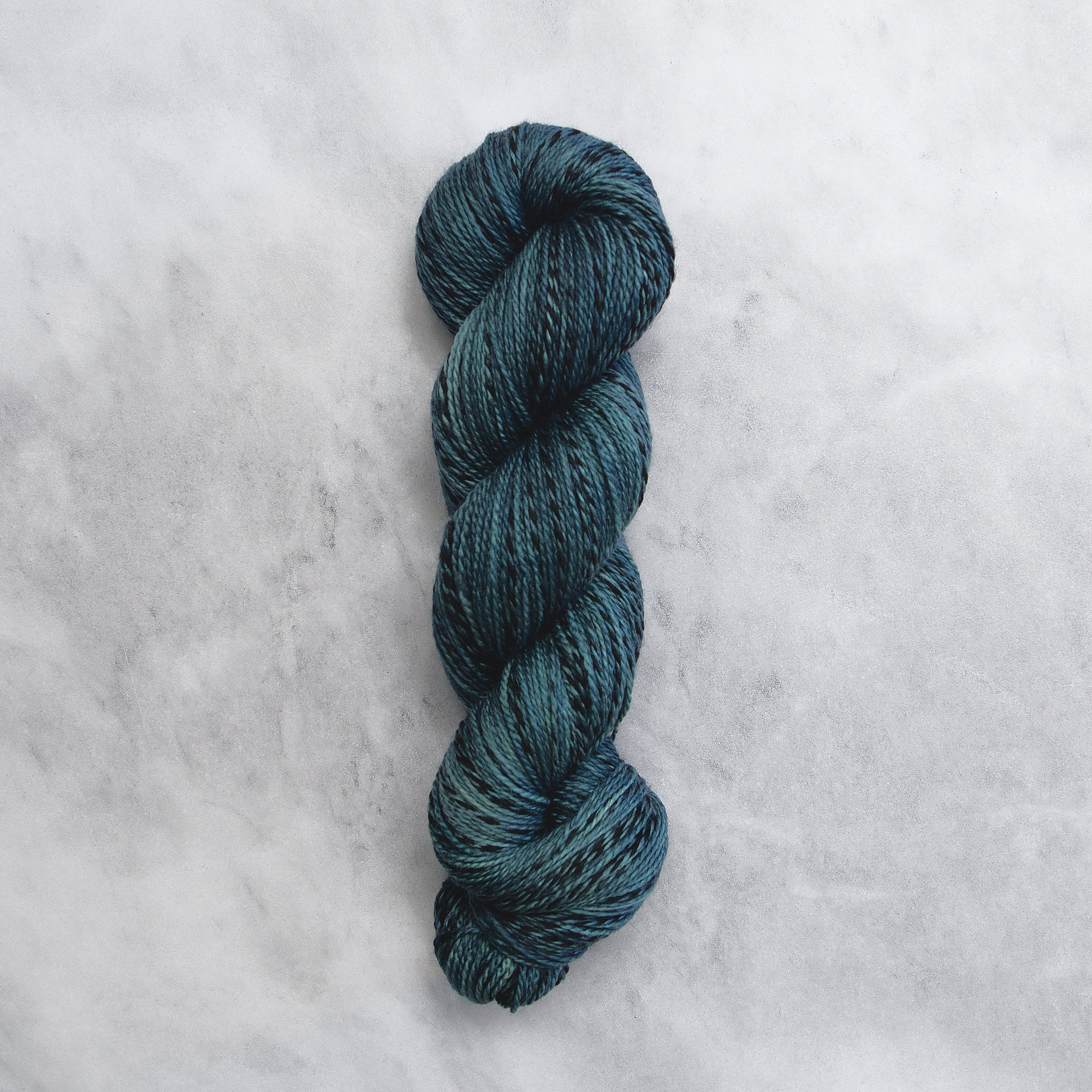 Dark ocean blue skein of yarn with black stripes.