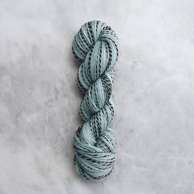 Light ocean blue skein of yarn with black stripes.