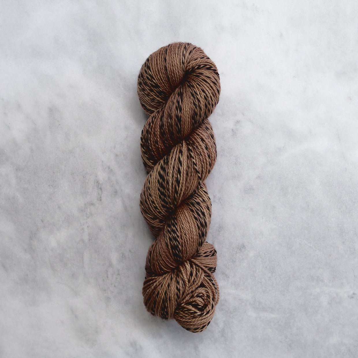 Medium brown skein of yarn with black stripes.