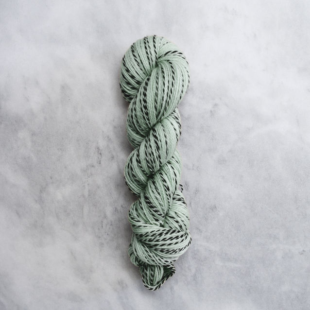 Mint green skein of yarn with black stripes.