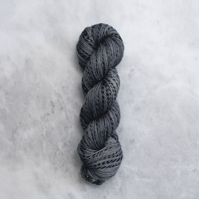 Medium grey skein of yarn with black stripes.