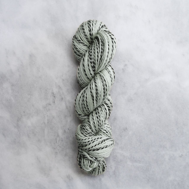 Light grey-green skein of yarn with black stripes.