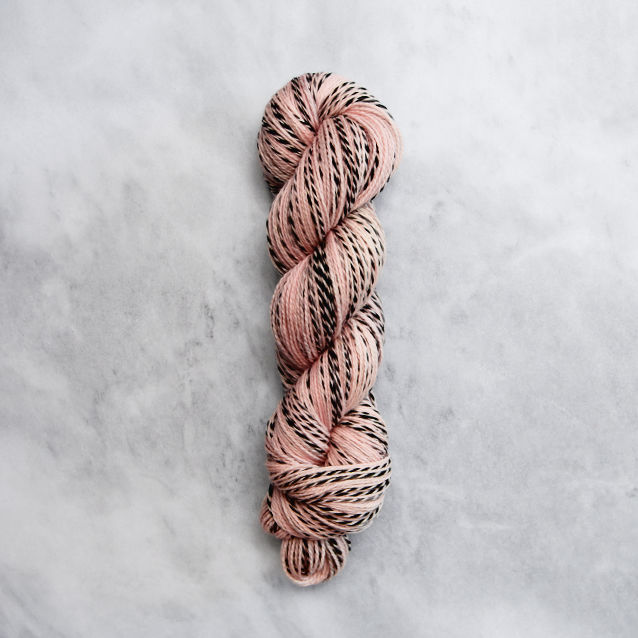 Dark peachy pink skein of yarn with black stripes.