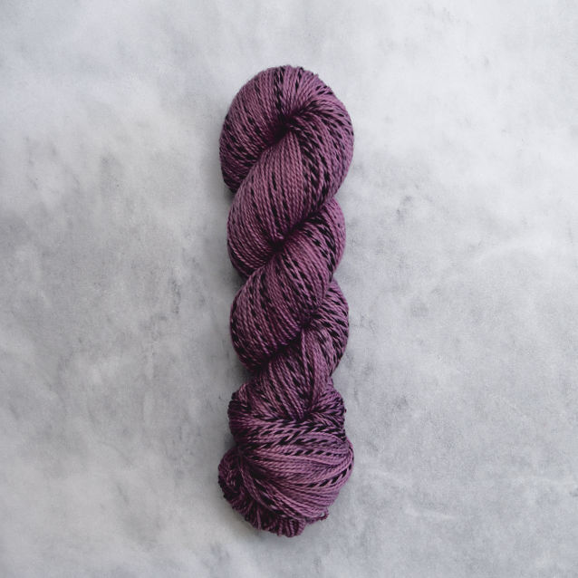 Medium violet skein of yarn with black stripes.