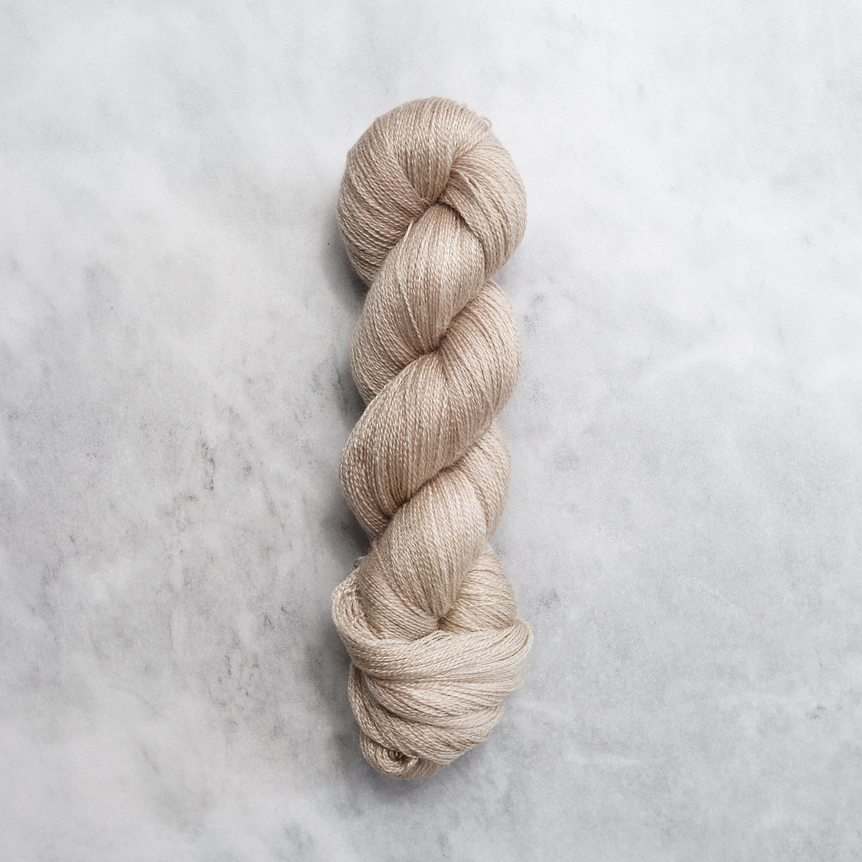 Light brown skein of yarn with silver shimmer.