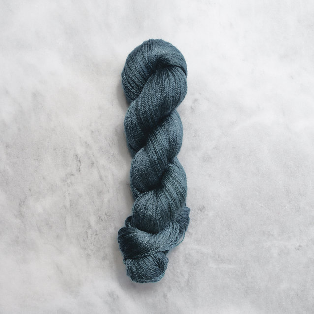 Dark ocean blue skein of yarn with silver shimmer.